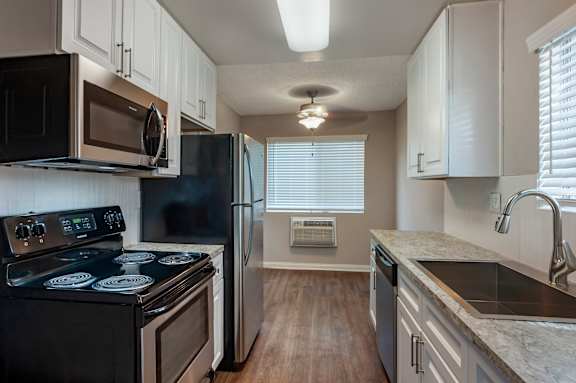 a kitchen with white cabinets and black appliances at Scripps Poway Villas, Poway, 92064