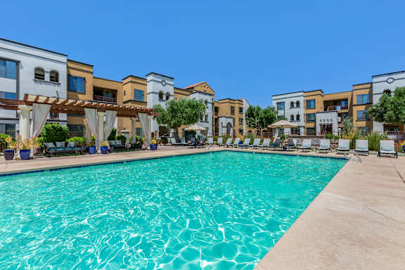 a swimming pool with apartments in the background at Trevi Apartment Homes, Arizona