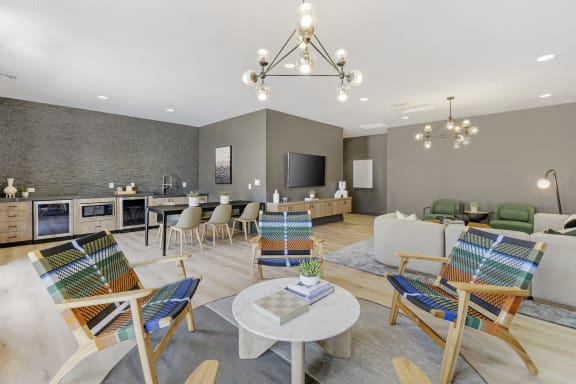 a living room with chairs and tables and a kitchen at The Michael B Townhomes and Flats, Las Vegas, NV