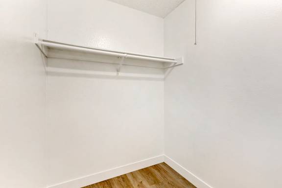 the bedroom of our studio apartment atrium with white walls and a white shelf