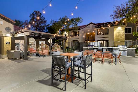 A patio with chairs and tables is set up outside a building.