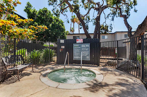 a hot tub sits in front of a black fence with a tree in the background at Scripps Poway Villas, California