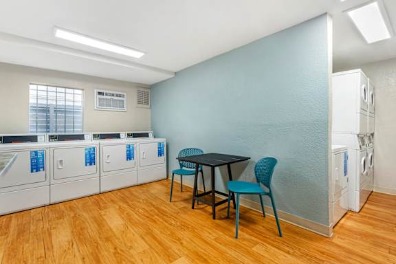 a room with a table and chairs and washers and dryers