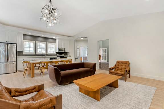 A modern living room with a brown leather sofa and a wooden coffee table.