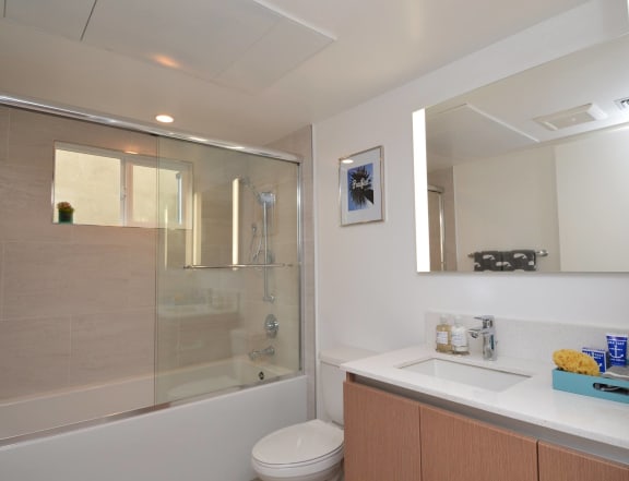 a bathroom with a shower sink and toilet in a 555 waverly unit