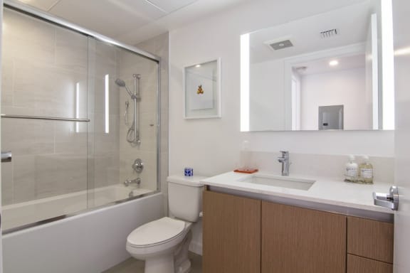 a bathroom with a shower toilet and sink in a 555 waverly unit