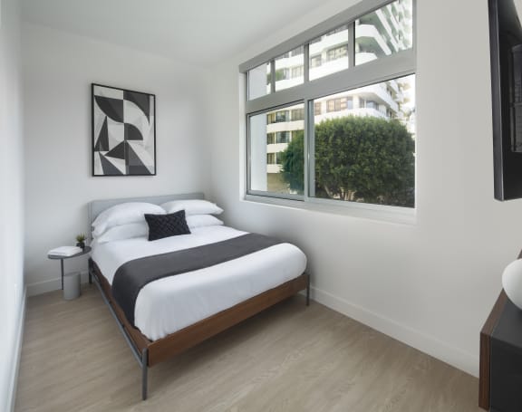 a bedroom with a bed and a window in a 555 waverly unit