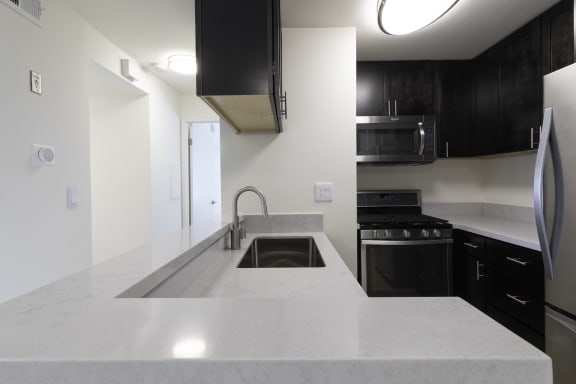 a kitchen with white countertops and black cabinets