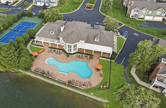 a mansion with an aerial view of a swimming pool and tennis court