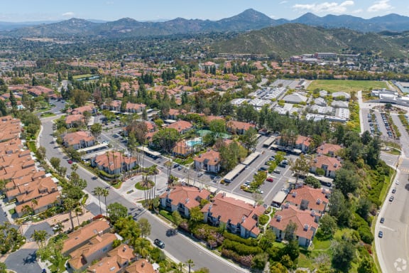 an aerial view of a neighborhood with houses and trees and mountains in the background at La Serena, San Diego, 92128