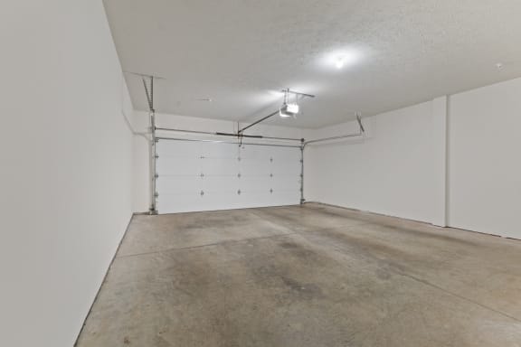 the interior of a garage with a concrete floor and white walls