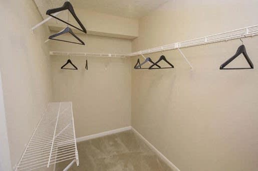a walk in closet with hanging racks and a table