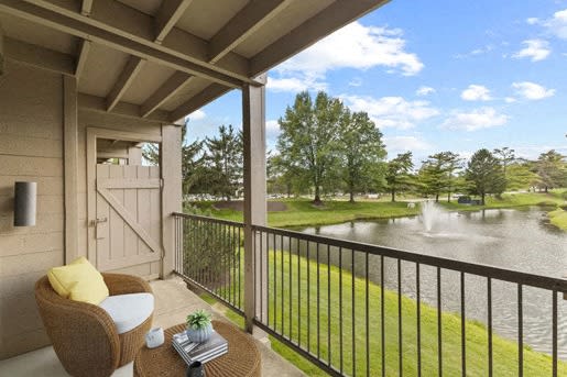 a balcony with a view of a lake and a fountain