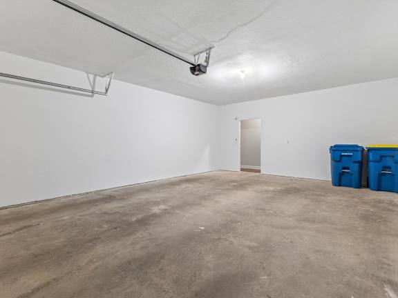 a large empty room with white walls and concrete floors
