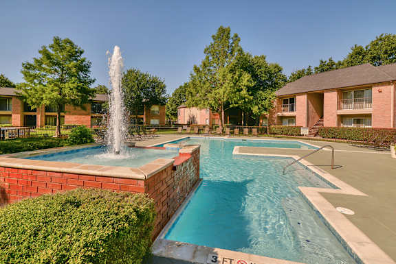 A pool with a fountain in the middle of it.