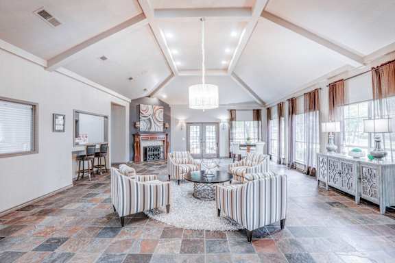 A living room with a fireplace and striped chairs at Trinity Square Apartments Texas