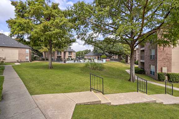 A residential area with apartment buildings and a sidewalk.