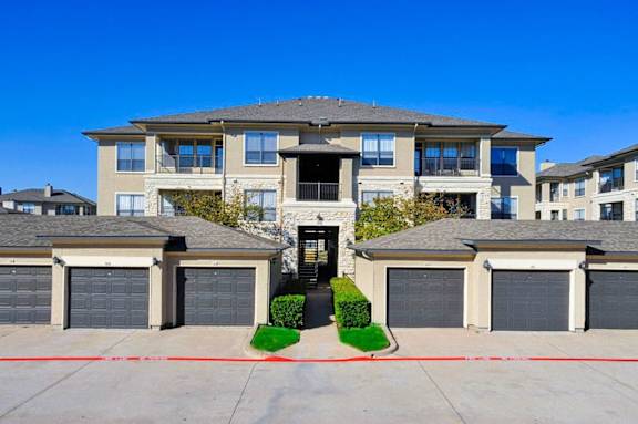 A large, modern house with a garage in front at Cypress Lake at Stonebriar Apartments, Frisco Texas