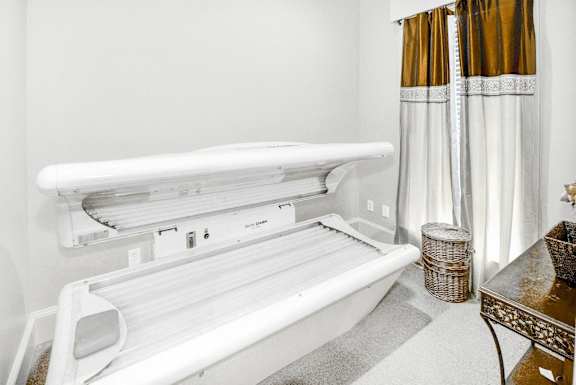 A white bathtub with a shower head and a basket beside it at Cypress Lake at Stonebriar Apartments, Frisco, TX