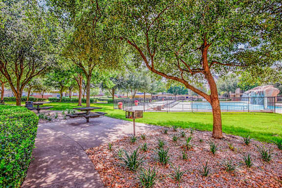 A park with a walking path, benches, and trees at Tuscany Square Apartments, Dallas, TX 75287