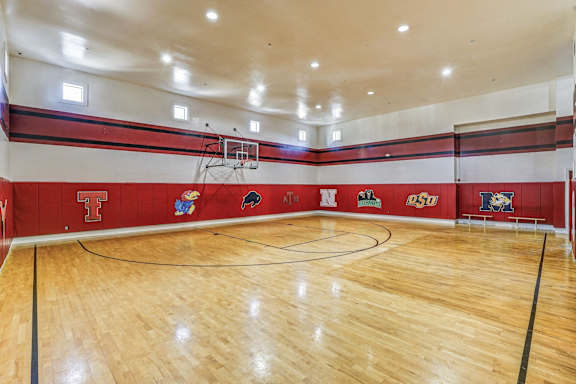 A basketball court with a wooden floor and a basketball hoop at Cypress Lake at Stonebriar Apartments, Frisco, TX 75034