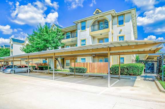 A large, modern building with a parking lot in front at Tuscany Square Apartments, Dallas, 75287