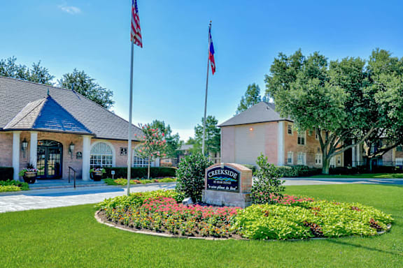 The entrance to Creekside Estates is marked by a large sign and two flags.