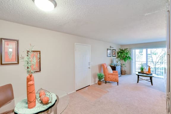 A living room with a carrot vase on a table.