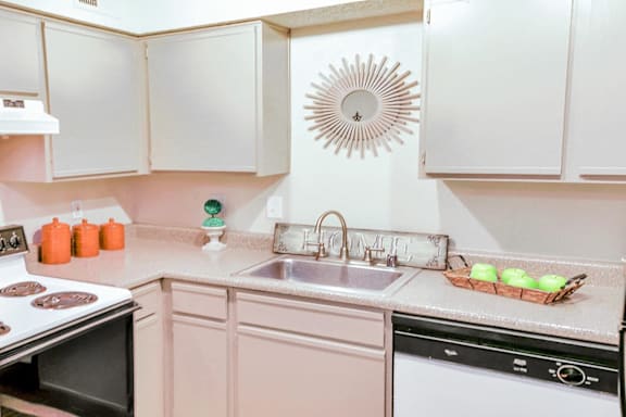 A kitchen with a stove, oven, and sink.