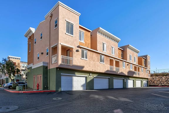 A multi-story building with a parking lot in front.