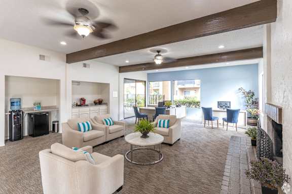 A living room with a white couch and a ceiling fan  3. at Woodlake Apartments, Escondido, 92027