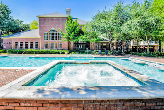 A pool with a hot tub in front of a house.