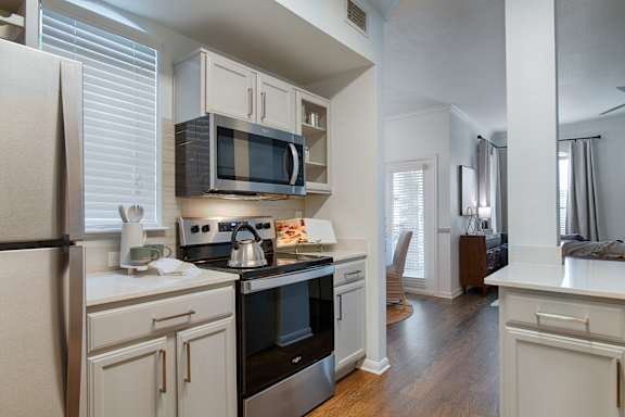 A kitchen with a stove, oven, and microwave.