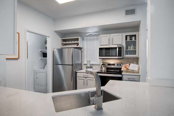 A modern kitchen with stainless steel appliances and white cabinets.