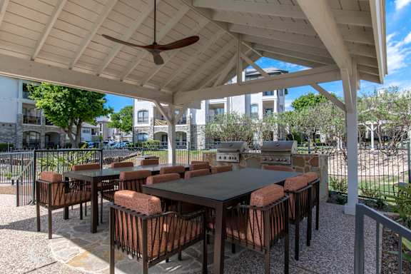 A patio with a table and chairs under a roof.