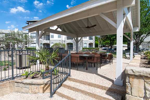 A patio with a table and chairs under a roof.