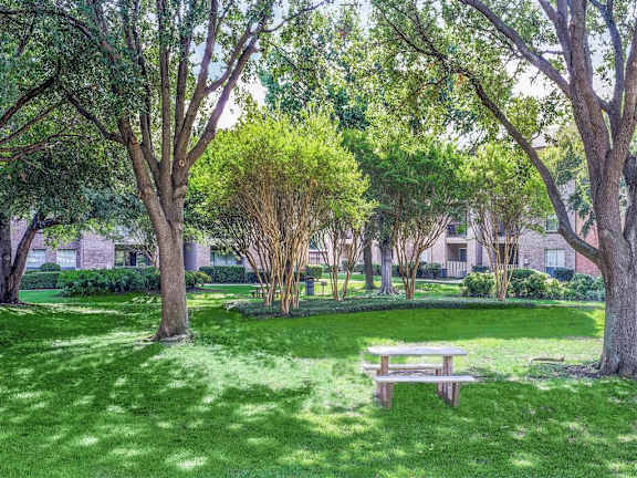 A park with a bench and trees at Trinity Square Apartments, Texas, 75287