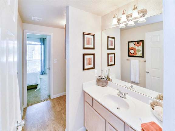 A bathroom with a white sink and a mirror above it.