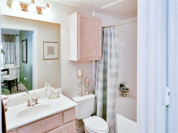 A bathroom with a sink, toilet, and shower at Bentley Place Apartments, Plano, TX