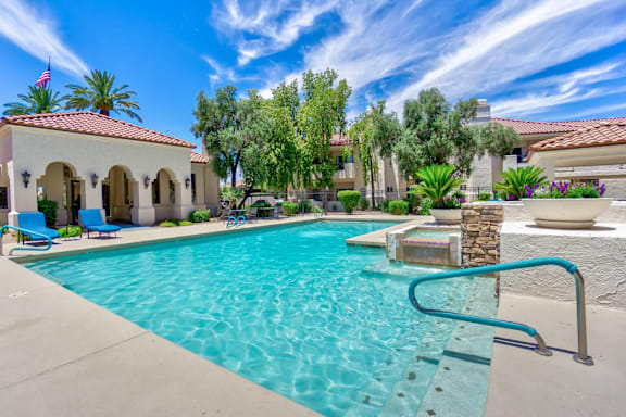 A pool with a slide and a house in the background.