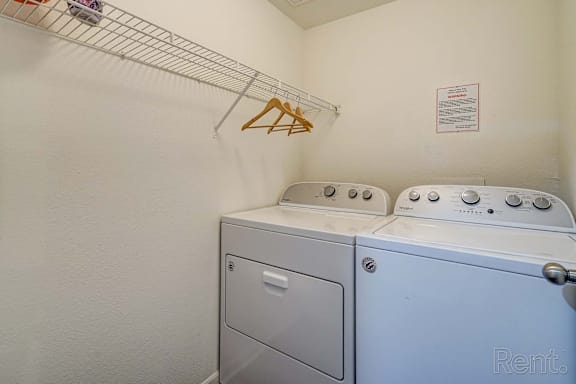 A white washing machine and dryer in a small laundry room.