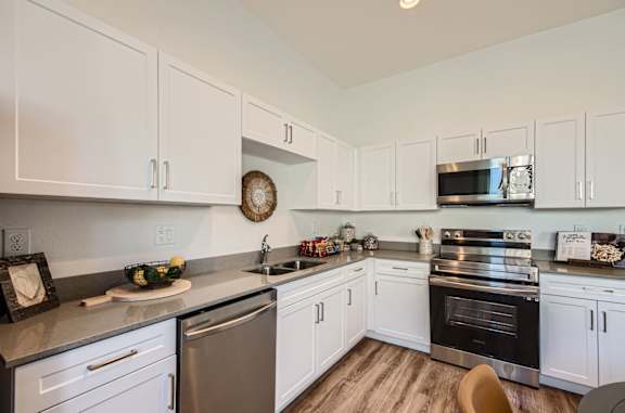 A kitchen with white cabinets and stainless steel appliances.