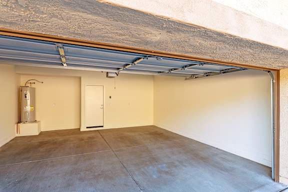 A garage with a concrete floor and a white door.