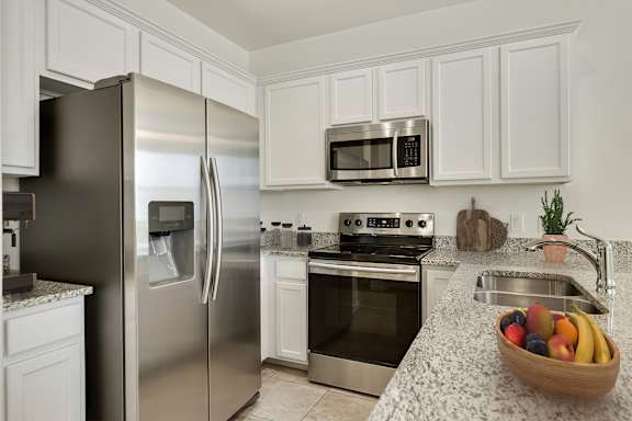 A kitchen with a stainless steel refrigerator, oven, and microwave.