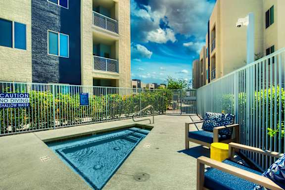 A pool with a sign that says no diving shallow water. at Craft at Gilbert and Baseline Apartments, Mesa