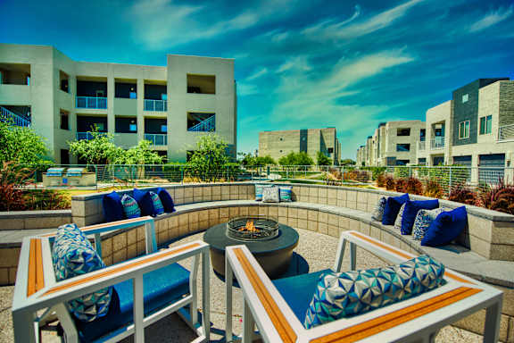 A patio with a fire pit and chairs at Craft at Gilbert and Baseline Apartments, Apartments, Mesa, AZ