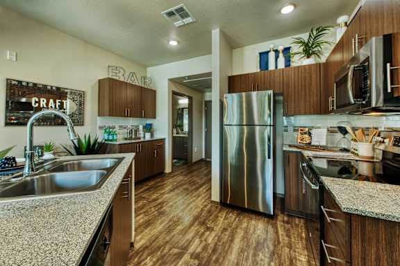 A modern kitchen with wooden cabinets and a stainless steel refrigerator. at Craft at Gilbert and Baseline Apartments, Mesa, Arizona