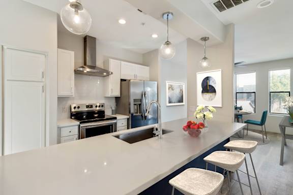 A modern kitchen with a large island and stools.