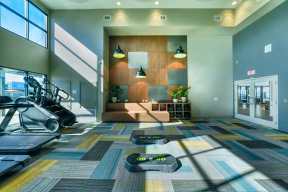 A treadmill is in the middle of a colorful room.