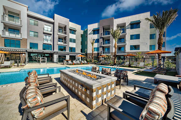 A poolside area with lounge chairs and a table.